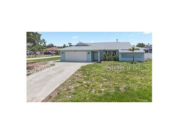 Charming single-story home with a well-maintained lawn and attached two-car garage at 7322 Ellis Ln, Port Charlotte, FL 33981