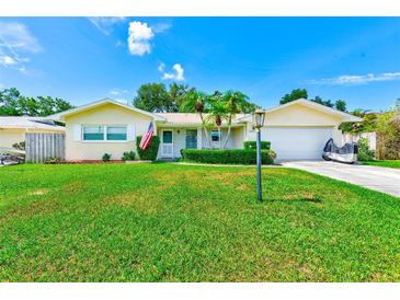 Charming single-story home with a well-maintained lawn, a two-car garage, and a cozy front porch at 11082 90Th Ter, Seminole, FL 33772