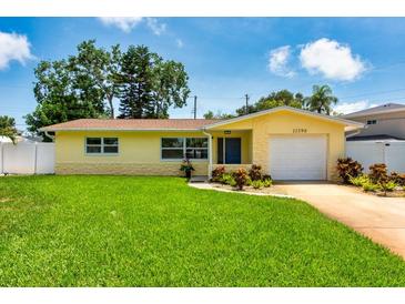 Charming yellow single-story home with a well-manicured lawn and attached garage, perfect curb appeal at 11398 88Th Ave, Seminole, FL 33772