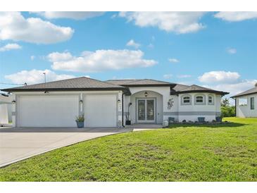 Charming single-story home featuring a two-car garage, landscaped front yard, and a welcoming entrance under a sunny sky at 200 Eppinger Dr, Port Charlotte, FL 33953