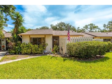 Charming single-story home featuring a well-manicured lawn, mature landscaping, and a quaint picket fence at 2922 60Th W St, Bradenton, FL 34209