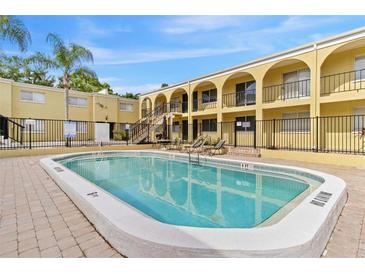Inviting community pool surrounded by lush landscaping and lounge chairs at 3206 W Azeele St # 120, Tampa, FL 33609