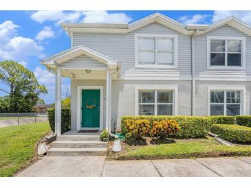 Charming townhome featuring a welcoming green front door and neat landscaping at 5501 67Th N Ave # 11, Pinellas Park, FL 33781