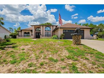 Stunning single Gathering home with a large front yard and an American flag at 6123 India Dr, Spring Hill, FL 34608