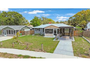 Charming single-story home with a well-maintained front yard, screened in porch, and a covered driveway at 1010 E Fern St, Tampa, FL 33604