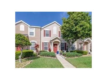 Charming townhome featuring a well manicured lawn, colorful front door and red shutters at 1415 Sedgwick Dr, Wesley Chapel, FL 33543