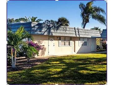 Quaint single story home featuring a well-manicured lawn and decorative palm trees for a charming curb appeal at 1802 Bedford Ter # 170, Sun City Center, FL 33573