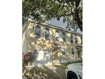 Charming townhome featuring a one-car garage, updated windows, and red tile roofing at 310 S Willow Ave # A, Tampa, FL 33606