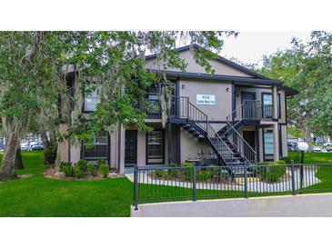 Inviting two-story apartment building featuring well-maintained landscaping and secure stairwell access at 4012 Tumble Wood Trl # 104, Tampa, FL 33613
