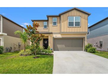 Charming two-story home with a well-manicured lawn, an attached garage, and beautiful landscaping at 9815 Carabiner Way, Land O Lakes, FL 34637