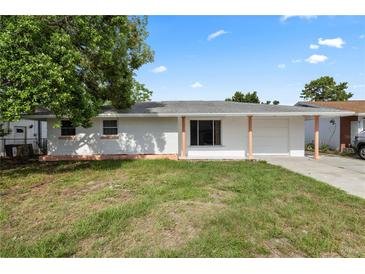 Charming single-story home with a well-maintained lawn and covered porch at 10730 Premier Ave, Port Richey, FL 34668