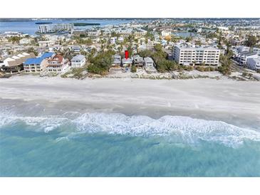 Stunning aerial view of beach home on the ocean with clear, turquoise water at 12458 1St W St, Treasure Island, FL 33706
