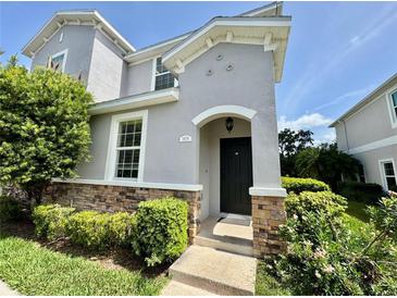 Inviting two-story home featuring a charming front entrance with stone accents and lush landscaping at 1878 Greenwood Valley Dr, Plant City, FL 33563