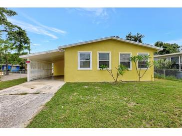 Charming yellow single-story home with a carport and a well-maintained lawn at 1903 24Th St, Sarasota, FL 34234