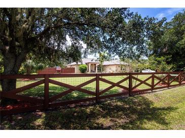 Charming single-story home with well-maintained lawn and decorative wooden fence at 408 River Bed Ct, Wimauma, FL 33598