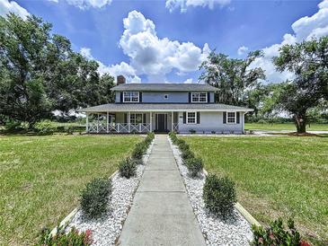 Charming two-story home featuring a welcoming porch and well-manicured landscaping at 5007 Booth Rd, Plant City, FL 33565