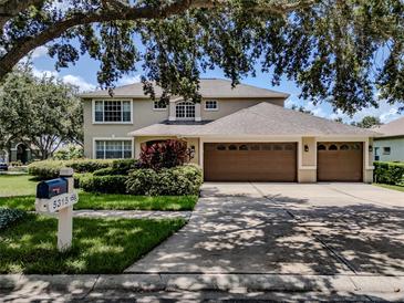 Charming two-story home featuring a three-car garage, lush landscaping, and a well-manicured lawn at 5315 Cedarshake Ln, Valrico, FL 33596