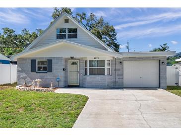 Charming one-story home with stone accents, a garage and a well-manicured lawn at 8074 37Th N Ave, St Petersburg, FL 33710