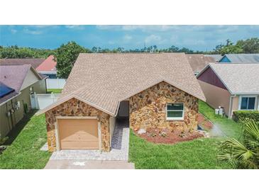 Charming single-story home featuring a stone facade, well-manicured lawn, and attached garage at 1331 Coolmont Dr, Brandon, FL 33511