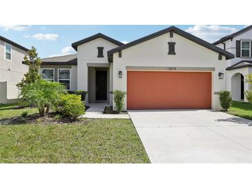 Charming single-story home featuring a two-car garage, a well-manicured lawn, and lovely curb appeal at 13515 Palmera Vista Dr, Riverview, FL 33579