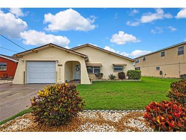 Charming single-story home featuring a well-manicured lawn and colorful landscaping at 13814 Lavender Ave, Hudson, FL 34667