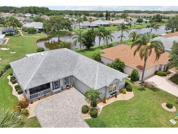 Stunning home showcasing a beautiful gray roof, landscaped yard and charming curb appeal at 2306 Emerald Lake Dr, Sun City Center, FL 33573