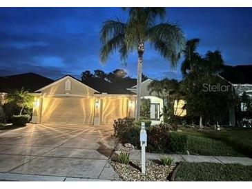 Night view of a single-Gathering home with well-maintained landscaping and a three-car garage at 2810 Ravendale Ln, Holiday, FL 34691