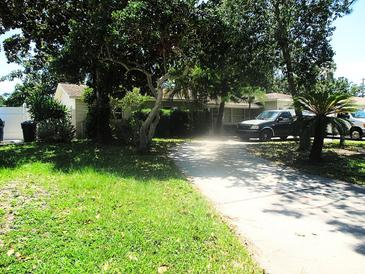 Charming single-story home with a well-manicured lawn and mature trees lining the driveway at 5468 26Th N Ave, St Petersburg, FL 33710