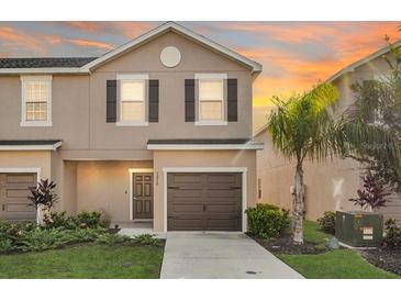 Inviting townhouse featuring a one-car garage, a well-maintained lawn and landscaping, and neutral exterior paint at 1218 Grantham Dr, Sarasota, FL 34234