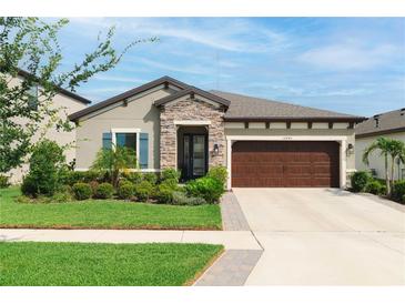 Charming single-story home featuring stone accents, manicured landscaping, and a two-car garage at 12643 Shetland Walk Dr, Lithia, FL 33547