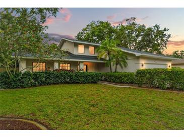 Charming home featuring a well-manicured lawn, lush landscaping, and a welcoming front entrance, perfect curb appeal at 2272 Adam Ct, Palm Harbor, FL 34683