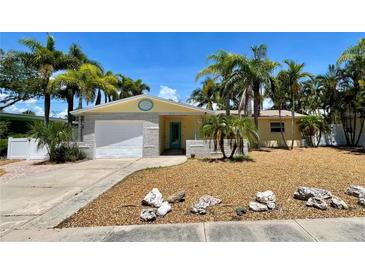 Charming single-story home with tropical landscaping, a driveway, and a one-car garage at 3014 58Th S St, Gulfport, FL 33707