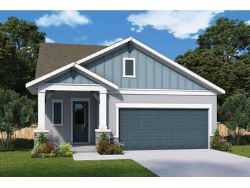 Charming single-story home featuring a craftsman-style facade, attached two-car garage, and manicured lawn at 31400 Pendleton Landing Cir, Wesley Chapel, FL 33545