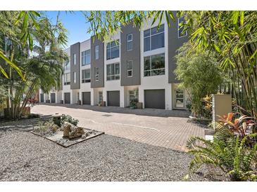 Modern townhome exteriors with gray and white facade, dark garage doors, and meticulously landscaped grounds at 325 5Th S Ave # 9, St Petersburg, FL 33701