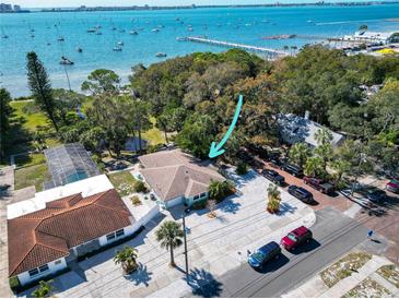 Beautiful waterfront home with lush landscaping and scenic views of the bay with boats and a pier at 5240 31St S Ave, Gulfport, FL 33707