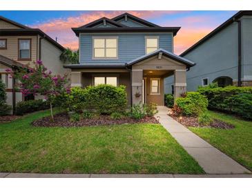 Charming two-story home showcasing a covered porch, manicured lawn, and vibrant landscaping at 5831 Caldera Ridge Dr, Lithia, FL 33547