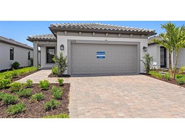Charming single-story home boasts a paved driveway, landscaped yard and neutral-colored stucco exterior at 6133 Wire Grass Ct, Nokomis, FL 34275