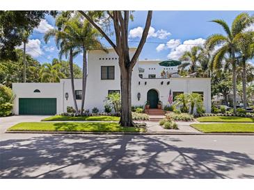 Stunning two-story home featuring lush landscaping, a barrel tile roof, and a rooftop terrace at 1920 Cherry Ne St, St Petersburg, FL 33704