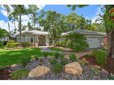 Charming single-story home featuring meticulously maintained landscaping, mature trees, and a welcoming front entrance at 3273 Tanglewood Trl, Palm Harbor, FL 34685