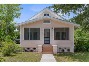 Charming, light pink home featuring a screened-in porch with brick-lined stairs and a well-maintained yard at 459 Bell Ave, Brooksville, FL 34601