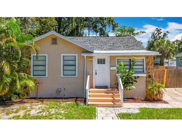 Charming single-story home featuring a beige stucco exterior and a well-manicured front yard at 1011 Newton S Ave, St Petersburg, FL 33705