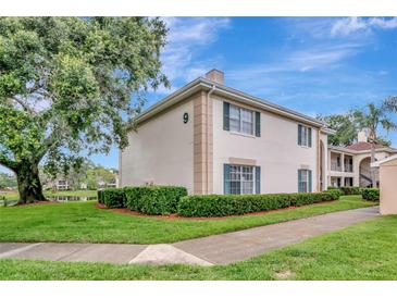 Inviting home exterior featuring lush landscaping, trimmed hedges, and a well-manicured lawn at 10330 Carrollwood Ln # 95, Tampa, FL 33618