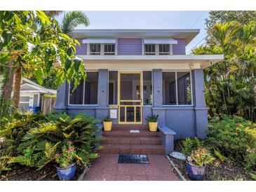 Charming home featuring a yellow screen door and vibrant potted plants flanking the steps at 1822 1St Se St, St Petersburg, FL 33705