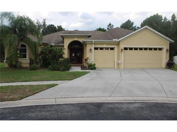 Charming one story home with a well-manicured lawn, two-car garage and neutral paint scheme at 1835 Fircrest Ct, Wesley Chapel, FL 33543