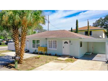 Charming single-story home with light blue siding, a brown roof and a well-manicured front yard at 1887 Springtime Ave, Clearwater, FL 33755