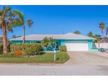 Charming turquoise waterfront home featuring lush landscaping, palm trees, and an attached two-car garage at 2010 E Vina Del Mar Blvd, St Pete Beach, FL 33706