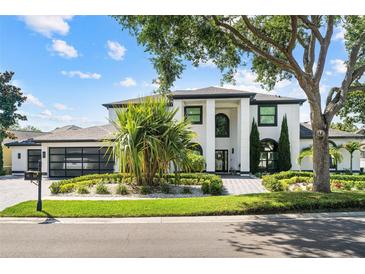 Stunning two-story home boasts a modern design, lush landscaping, and a brick driveway at 2819 Safe Harbor Dr, Tampa, FL 33618