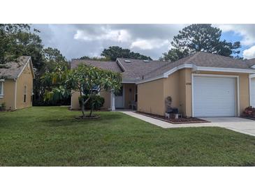 Well-maintained home features a lush green lawn and beautiful landscaping at 4206 Revere Cir, New Port Richey, FL 34653