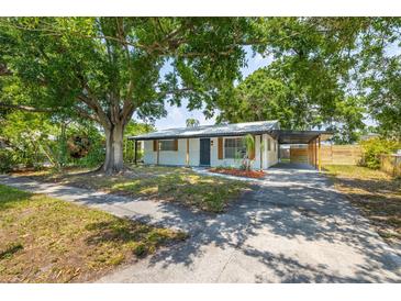 Charming single-story home with a covered parking area and mature trees, offering shade and curb appeal at 6304 S S Grady Ave, Tampa, FL 33616