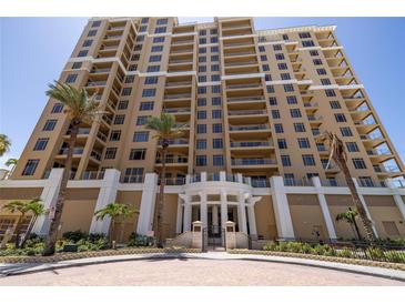 Stunning multi-story condominium building exterior with a manicured entrance and landscaping at 11 Baymont St # 505, Clearwater Beach, FL 33767